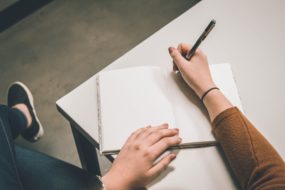 person writing on white paper