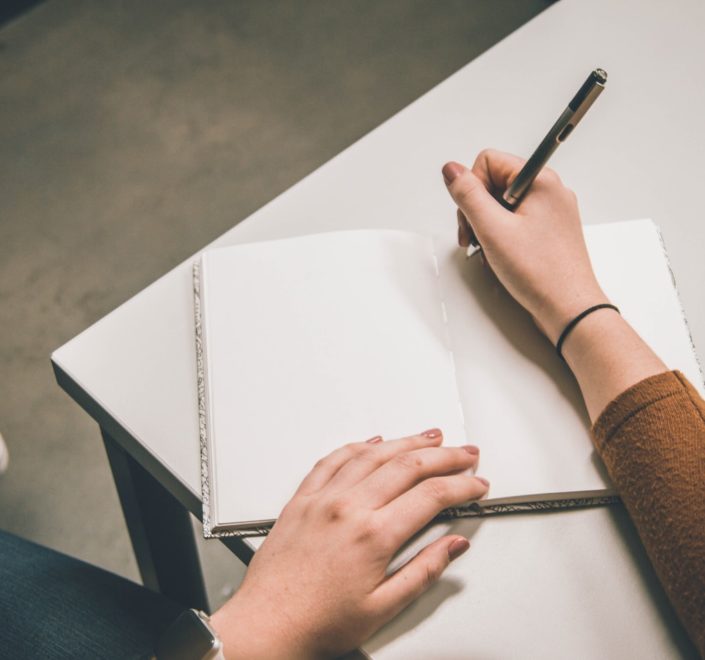 person writing on white paper