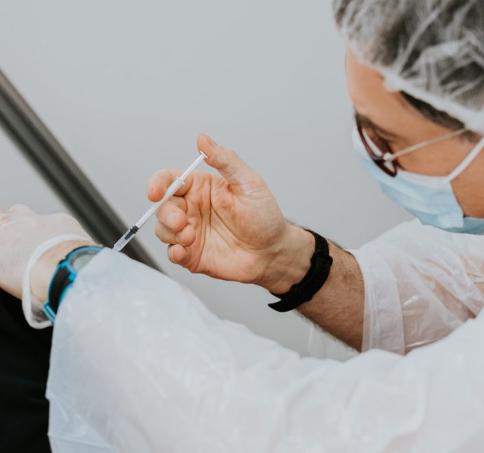 person in white long sleeve shirt holding gray pen