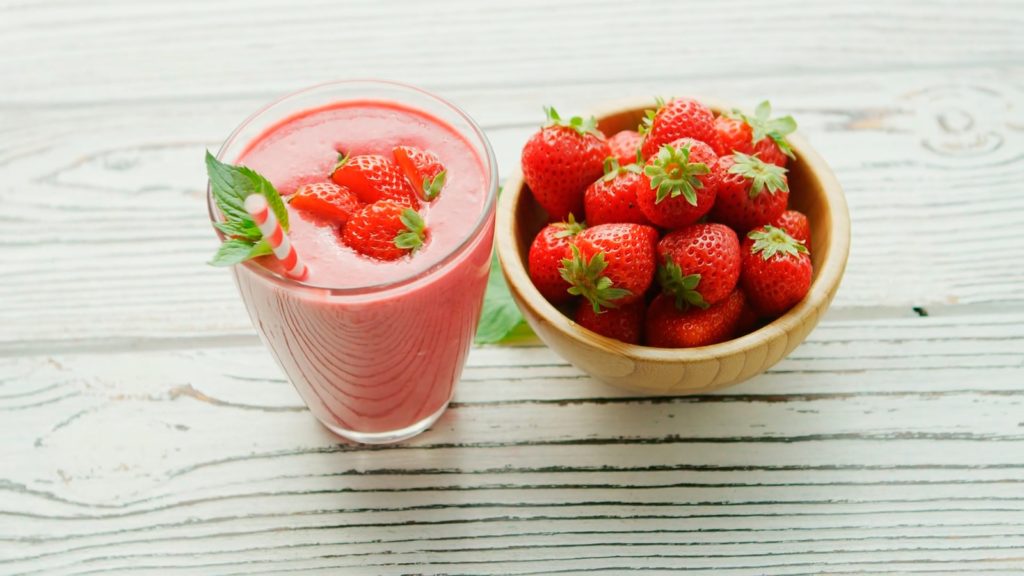 red strawberries in pink plastic cup