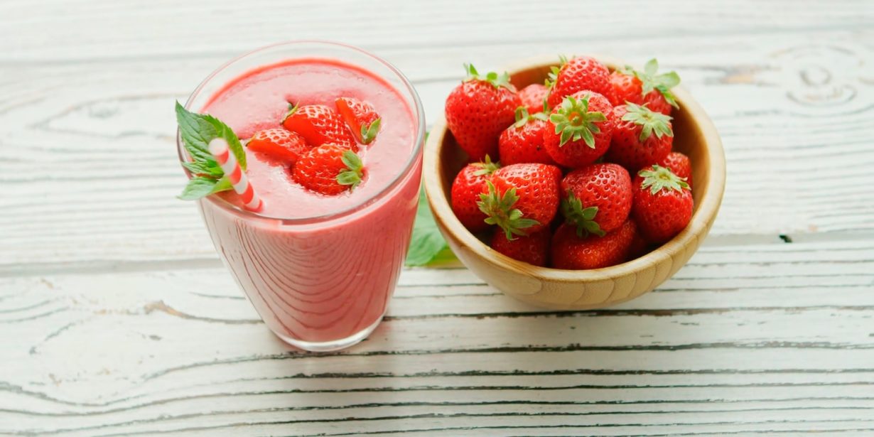 red strawberries in pink plastic cup