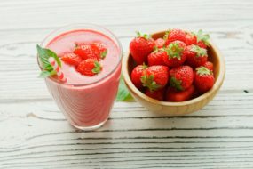red strawberries in pink plastic cup