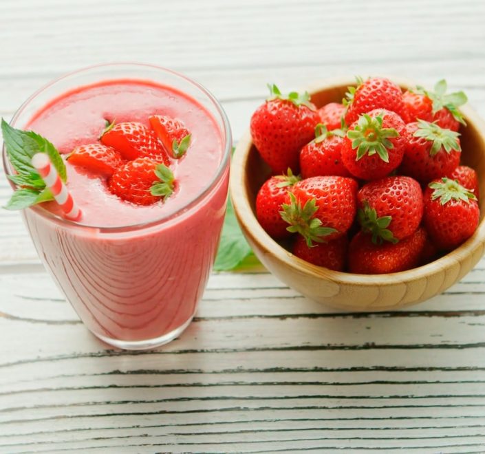 red strawberries in pink plastic cup